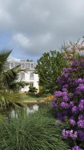 a house with purple flowers in front of a garden at Manoir de Lanveur in Fouesnant