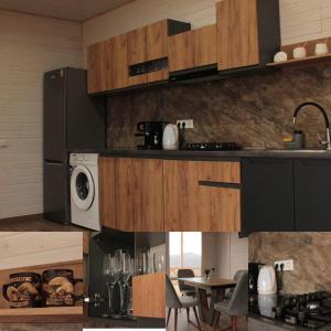 a kitchen with a microwave and a table with chairs at VaavHouse in Tyudov