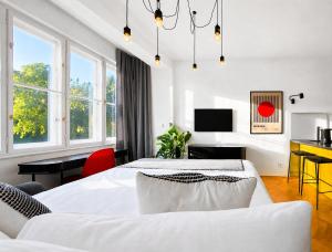 a white bedroom with a bed and a desk at Botanique Rooms with Sauna by Homester in Brno