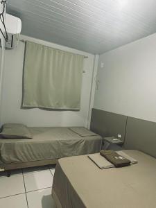 a room with two beds and a window in it at Hotel Real in Realeza
