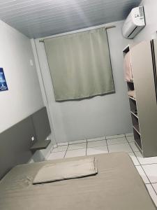 a small room with a bed and a window at Hotel Real in Realeza