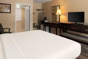 a hotel room with a bed and a desk with a television at Bay Breeze Inn in Seaside