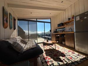 a living room with a couch and a large window at Cabañas La Ola Puertecillo in Navidad