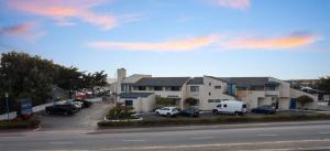 a building with cars parked in a parking lot at Bay Breeze Inn in Seaside