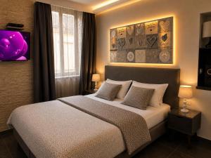 a bedroom with a large bed with two pillows at Appart' Spa et Sauna Privatif Au Cœur De Beaune in Beaune +17 photos