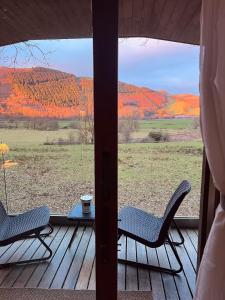 a view from a porch with two chairs and a table at Cosy Log Cabin in Machynlleth - Wales - Wifi & Parking in Machynlleth