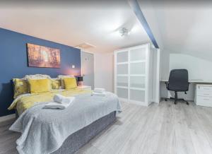 a bedroom with a large bed with a blue wall at Egremont Hide Away - Perfect contractor accommodation - Close to Sellafield in Woodend
