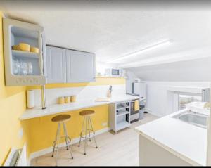 a kitchen with yellow and white cabinets and stools at Egremont Hide Away - Perfect contractor accommodation - Close to Sellafield in Woodend