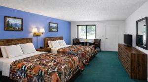 a hotel room with two beds and a flat screen tv at Branding Iron Motel in Chama
