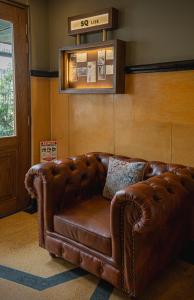 a brown leather couch sitting in a living room at 5Q House Quinta Camacho in Bogotá