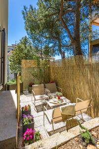 a patio with a table and chairs and a fence at New luxury apartment RABASOL in Rabac