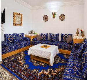 a living room with blue couches and a table at Maison Berj in Oualidia