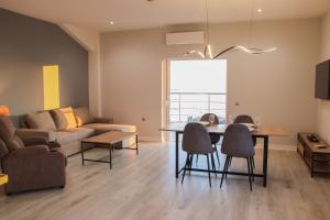 a living room with a table and chairs and a couch at Zeus Cosmos Apartments in Lourdata