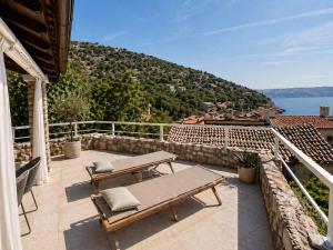 a patio with two benches and a view of the water at Apartments Casa al Vento in Donja Klada