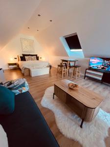 a living room with a bed and a table at Eden aux hirondelles in Samer