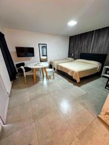 a bedroom with a bed and a table and a tv at Apart Piedras con cohera y desayuno seco in Villa María
