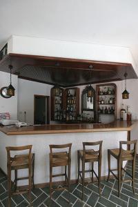 a bar with four wooden stools in a room at Atlantis Hotel in Naousa