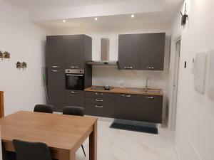 a kitchen with brown cabinets and a wooden table at Maison MariEtt - Smart & Living Suites - in Troia
