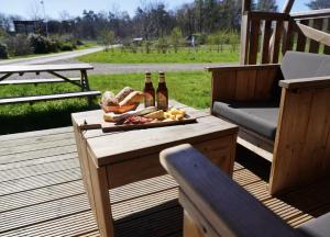 a table with bottles of beer and bread on a deck at F1 Ardennes Stay 5p Parking Bashfull in Amblève