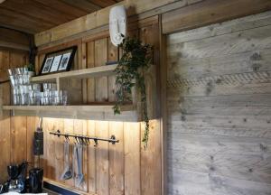 a kitchen with wooden walls and shelves with utensils at F1 Ardennes Stay 5p Parking Bashfull in Amblève +11 photos