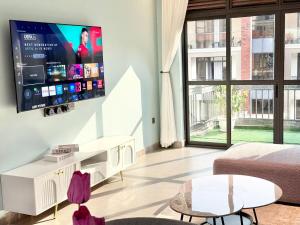 a living room with a large flat screen tv on a wall at comfort homes in Kampala