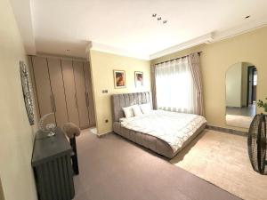 a bedroom with a bed and a large window at comfort homes in Kampala