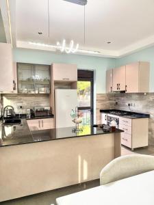 a kitchen with white cabinets and a black counter top at comfort homes in Kampala