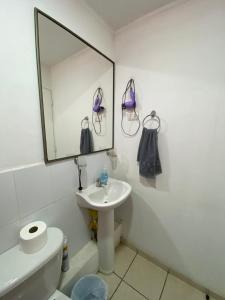 a bathroom with a sink and a mirror and a toilet at Condominio María Teresa in Quintero