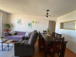 a living room with a purple couch and a table at Condominio María Teresa in Quintero