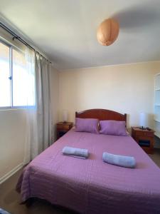 a bedroom with a purple bed with two pillows at Condominio María Teresa in Quintero