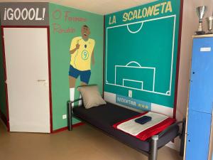 a room with a wall with a mural of a soccer player at Evasion Latine in Castelnau-Rivière-Basse