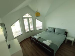 a bedroom with a bed with two white towels on it at Villa Paradiso in Ohrid