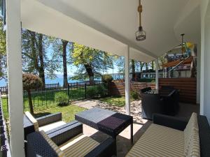 a porch with a table and chairs and a view of the water at Villa Paradiso in Ohrid