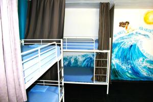 two bunk beds in a room with a wave on the wall at TravelBreak in Podgorica