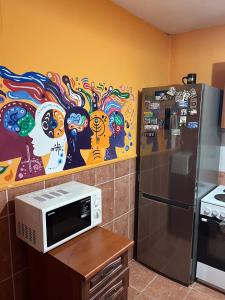 a kitchen with a microwave and a painting on the wall at TravelBreak in Podgorica