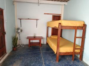 a room with two bunk beds and a table at Jandys house Lobitos in Barrio Bellavista