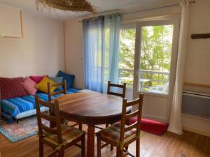 a dining room with a table and chairs and a couch at Oustau deu Beç in Verdaches