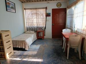 a bedroom with a bed and a desk and a table at Jandys house Lobitos in Barrio Bellavista