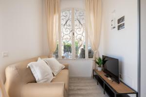 a living room with a couch and a window at Serena Armando Exclusive Villas with Private Pools in Rosa Marina