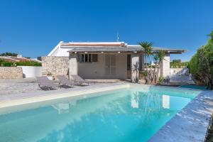 a swimming pool in front of a villa at Serena Armando Exclusive Villas with Private Pools in Rosa Marina