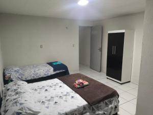 a bedroom with two beds and a black cabinet at Pousada Ouro branco Mossoró RN in Mossoró