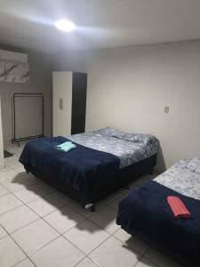two beds sitting in a room with at Pousada Ouro branco Mossoró RN in Mossoró +5 photos