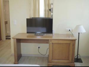 a wooden desk with a television on top of it at Hotel La Strada & Sultan in Murnau am Staffelsee