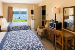 a hotel room with two beds and a desk at Baddeck Inn in Baddeck