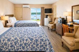 a hotel room with two beds and a desk and chairs at Baddeck Inn in Baddeck +7 photos