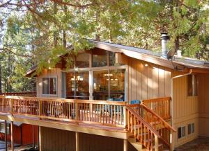 a house with a large deck in the woods at 10B Arrow Lodge in North Wawona