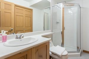 a bathroom with a white sink and a shower at Bright and Clean, Walk Everywhere, Shared Pool and Hot Tub in Whistler +9 photos