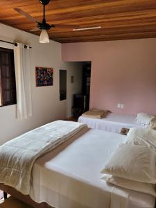 two beds in a bedroom with a ceiling at Pousada Chalés da Estalagem in São Bento do Sapucaí +50 photos