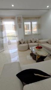 a living room with a couch and a table at Appartamento spazioso e luminoso in Mahdia
