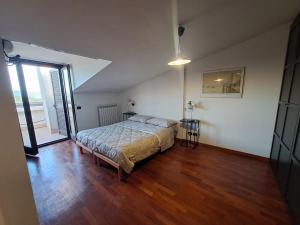a bedroom with a bed and a wooden floor at Casa Panorama Assisi in Perugia